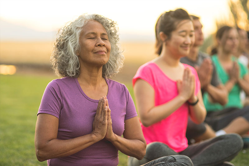 ladies practicing yoga in a garden